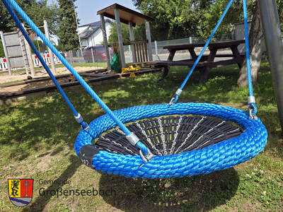 Im Juni 2024 hat der gemeindliche Bauhof am Spielplatz Hutweg in Großenseebach einige Spielgeräte ertüchtigt. Außerdem wurden ganz neue Geräte installiert, unter anderem diese gemütliche Nestschaukel.